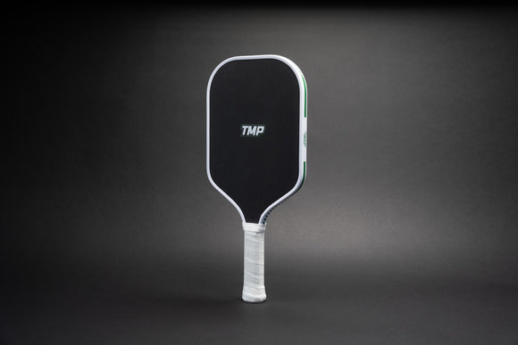 TMP Stealth Pickleball Paddle from Tickle My Pickle, angled view showing the TMP-branded black face with white frame, on a black gradient background