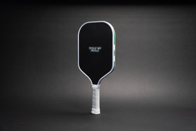 TMP Stealth Pickleball Paddle front view with the Tickle My Pickle wordmark on the black face, against a black gradient background