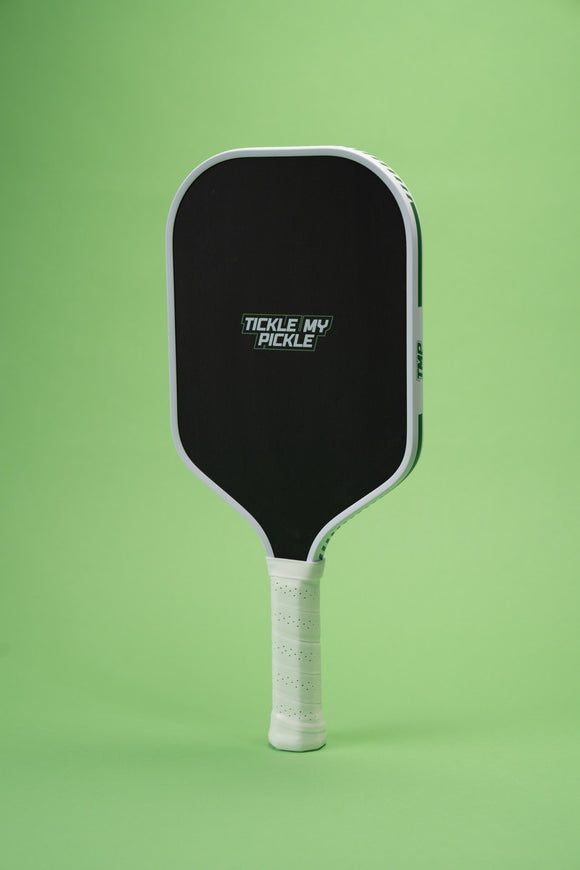 TMP Stealth Pickleball Paddle on a green background, full body view showing the Tickle My Pickle wordmark and white edge frame